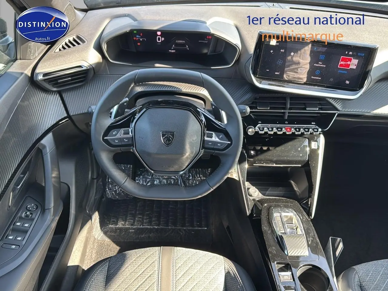 Vue intérieure du poste de conduite du Peugeot 2008 noir 2025, volant compact et écran tactile central lumineux.