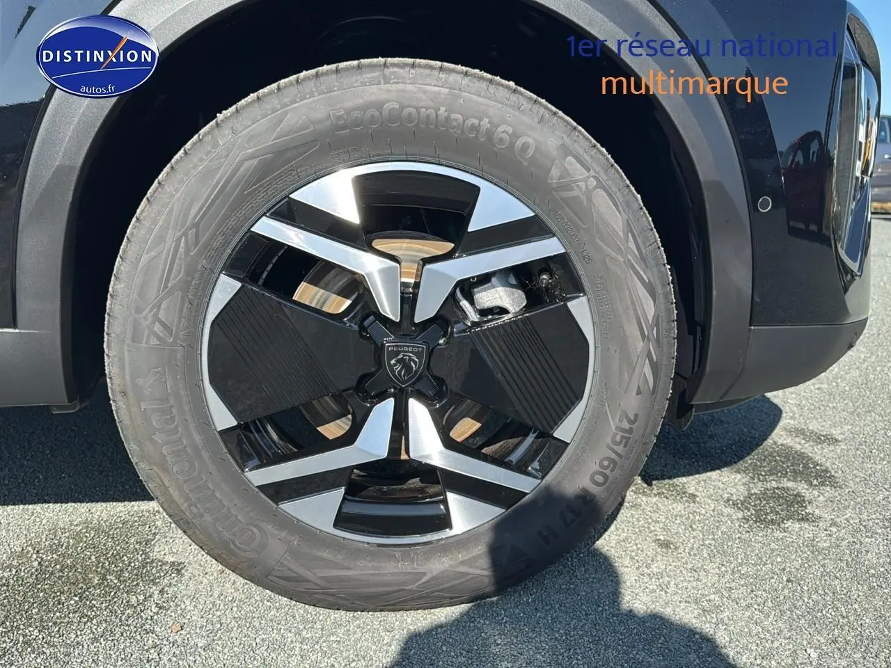 Gros plan sur la roue avant gauche noire avec jante alu au design moderne du Peugeot 2008 noir 2025.