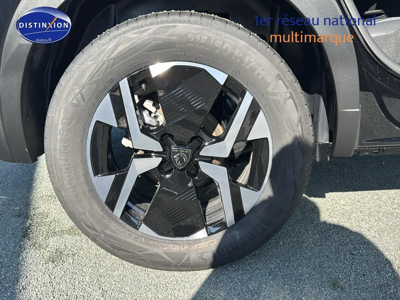 Gros plan sur la jante alu noire et grise du côté avant droit du Peugeot 2008 noir 1.2 hybrid 145 allure e-dcs6 2025