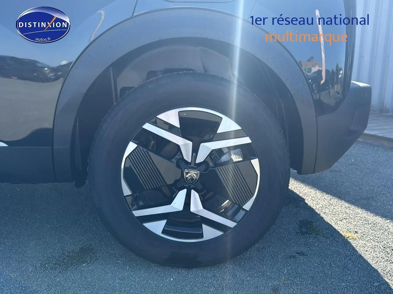 Gros plan sur la roue arrière droite noire du Peugeot 2008 1.2 hybrid 145 allure e-dcs6 avec jante alu design.