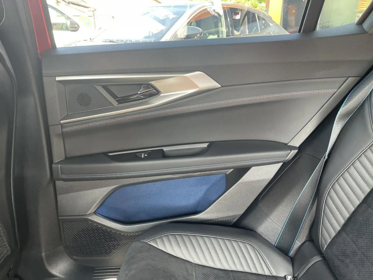 Vue intérieure côté droit arrière de la porte et siège noir avec surpiqûres bleues du Renault Rafale Esprit Alpine 2025.