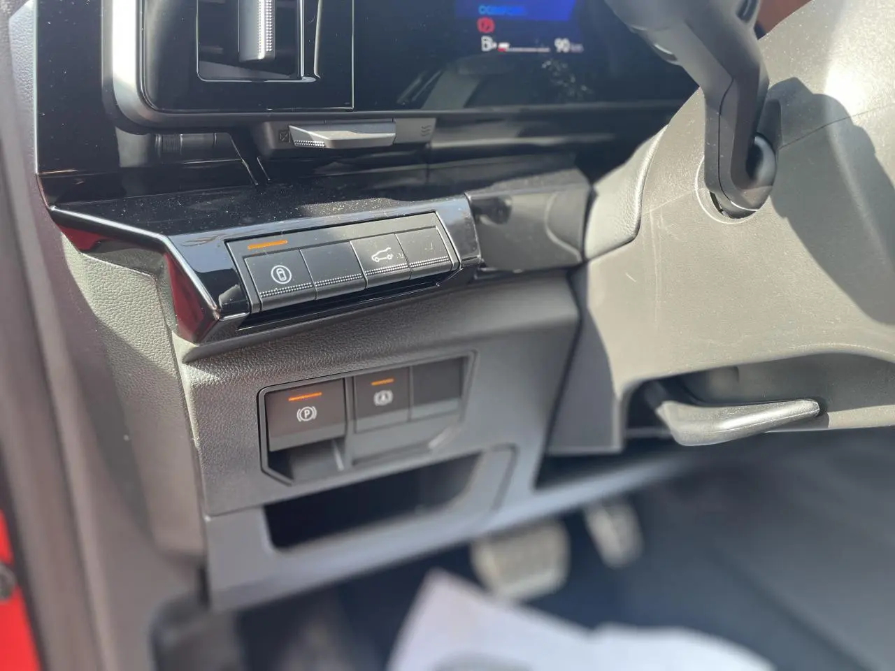 Gros plan sur les commandes sous le tableau de bord côté gauche du Renault Rafale rouge et noir, version Esprit Alpine 2025.