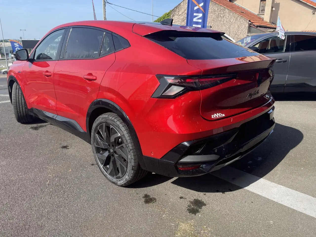 Vue 3/4 arrière droite du Renault Rafale 2025 rouge flamme avec toit noir et jantes noires diamantées.