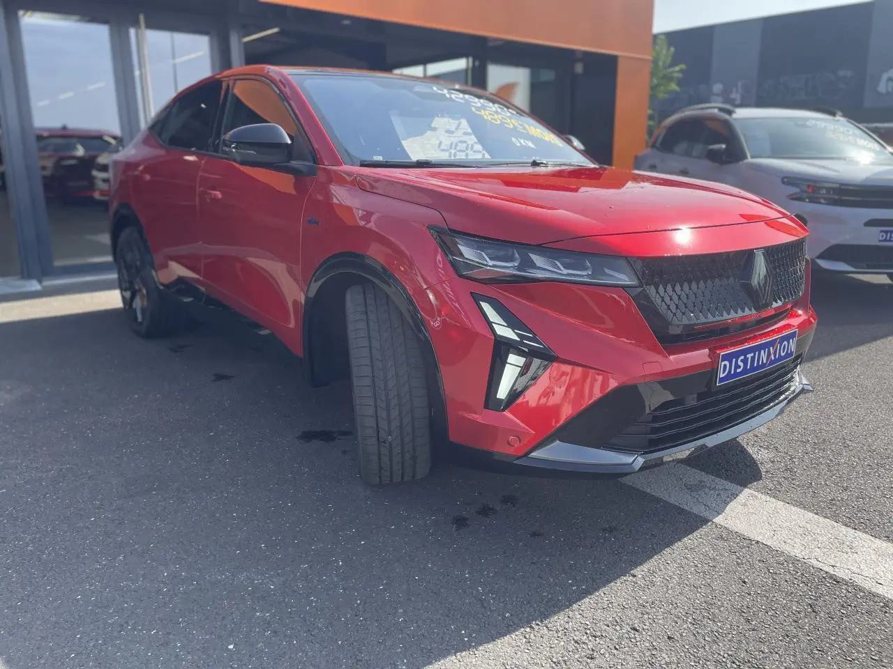 Renault Rafale rouge à toit noir vue 3/4 avant droit avec calandre noire et feux LED distinctifs.