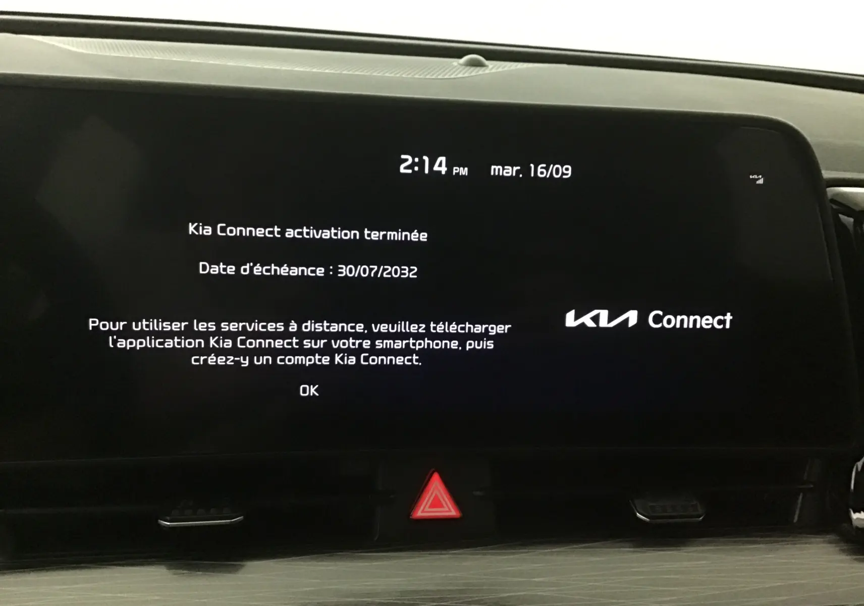 Écran digital 12,3'' du Kia Sportage 2025 affichant l'activation de Kia Connect avec bouton d'alerte rouge en dessous.