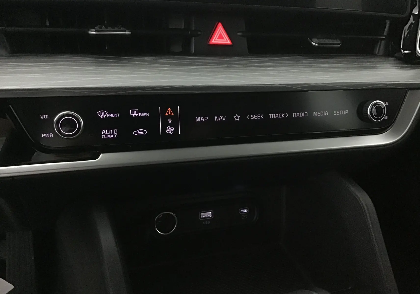 Détail du tableau de bord du Kia Sportage 2025 blanc, avec écran digital 12,3 pouces et commandes tactiles éclairées.