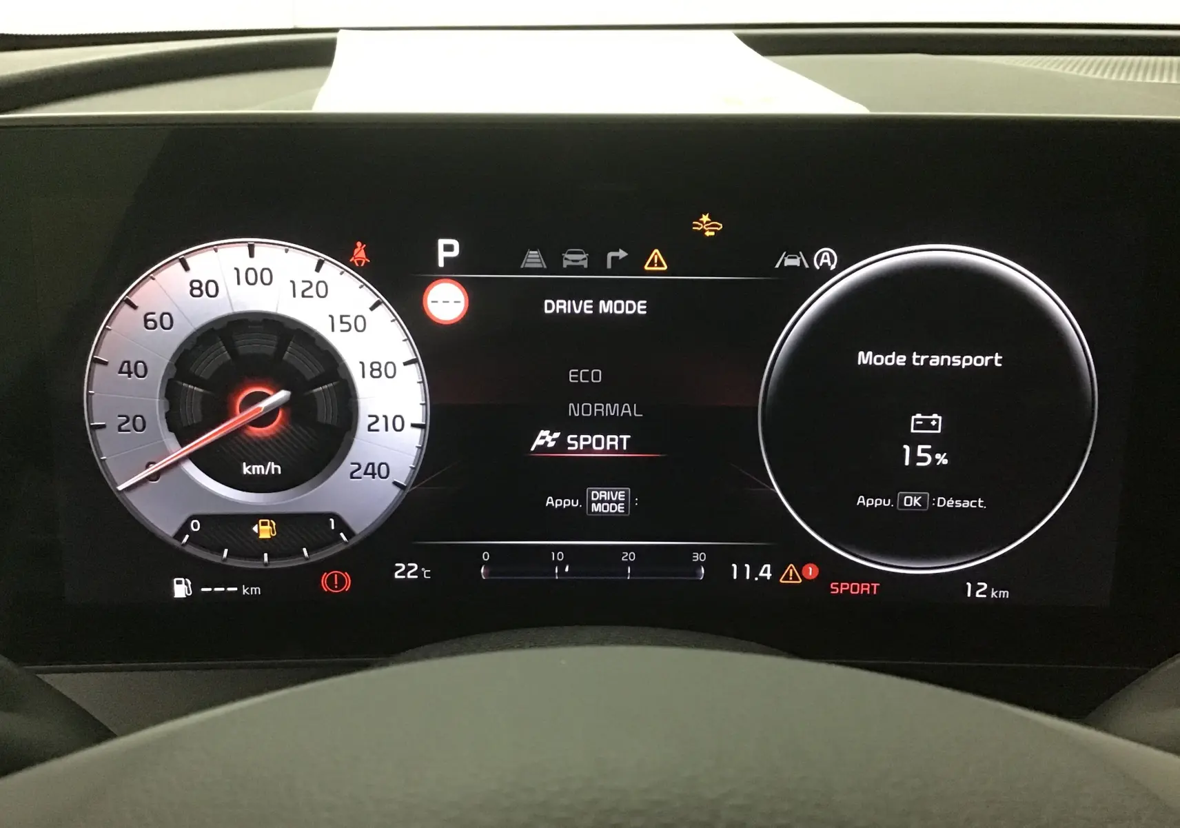 Combiné d'instrumentation digital 12,3'' du Kia Sportage 2025 affichant mode sport et niveau batterie à 15%