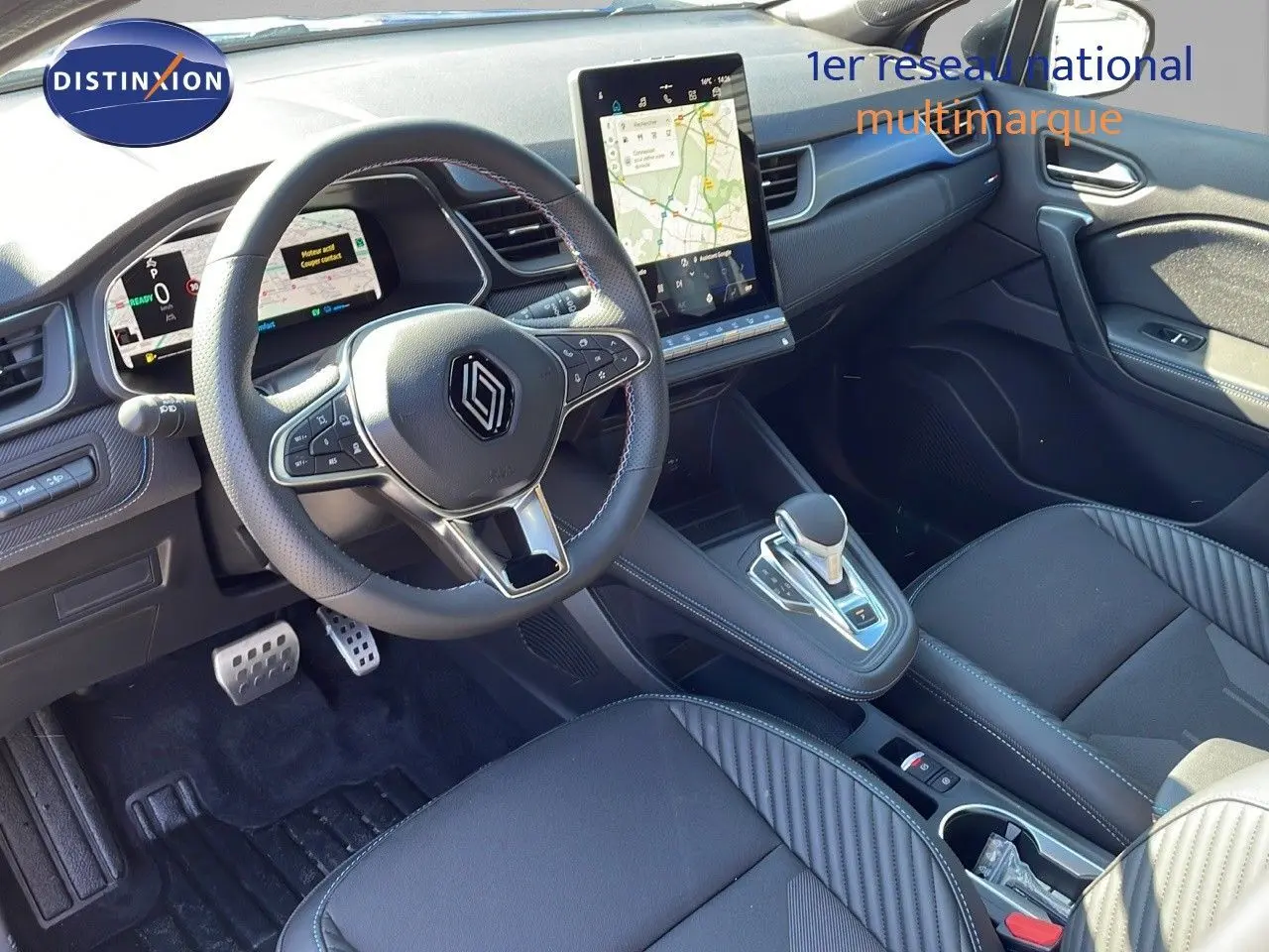 Intérieur du Renault Captur E-Tech hybride 2025, vue cockpit côté conducteur avec écran tactile vertical et volant multifonction noir.