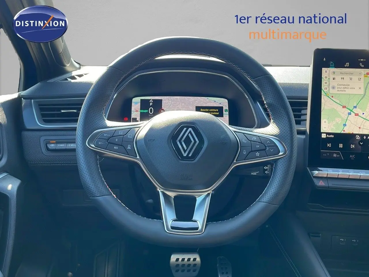 Vue rapprochée du volant et tableau de bord numérique du Renault Captur E-Tech hybride 2025 avec écran tactile.