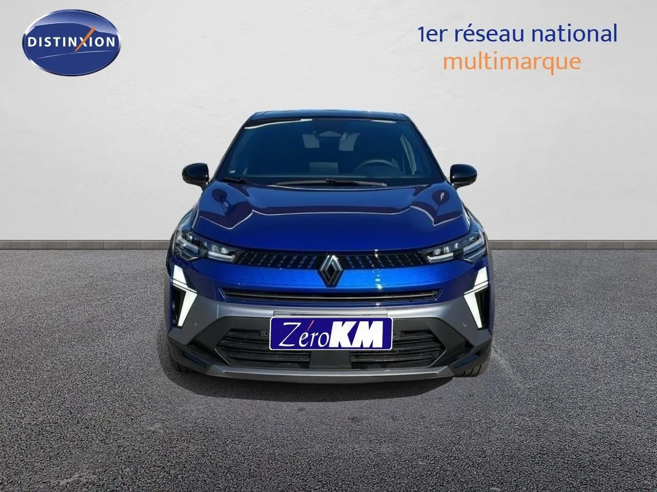 Vue frontale d'une Renault Captur E-Tech hybride 2025 en bleu Iron Metal avec toit noir et feux LED allumés.