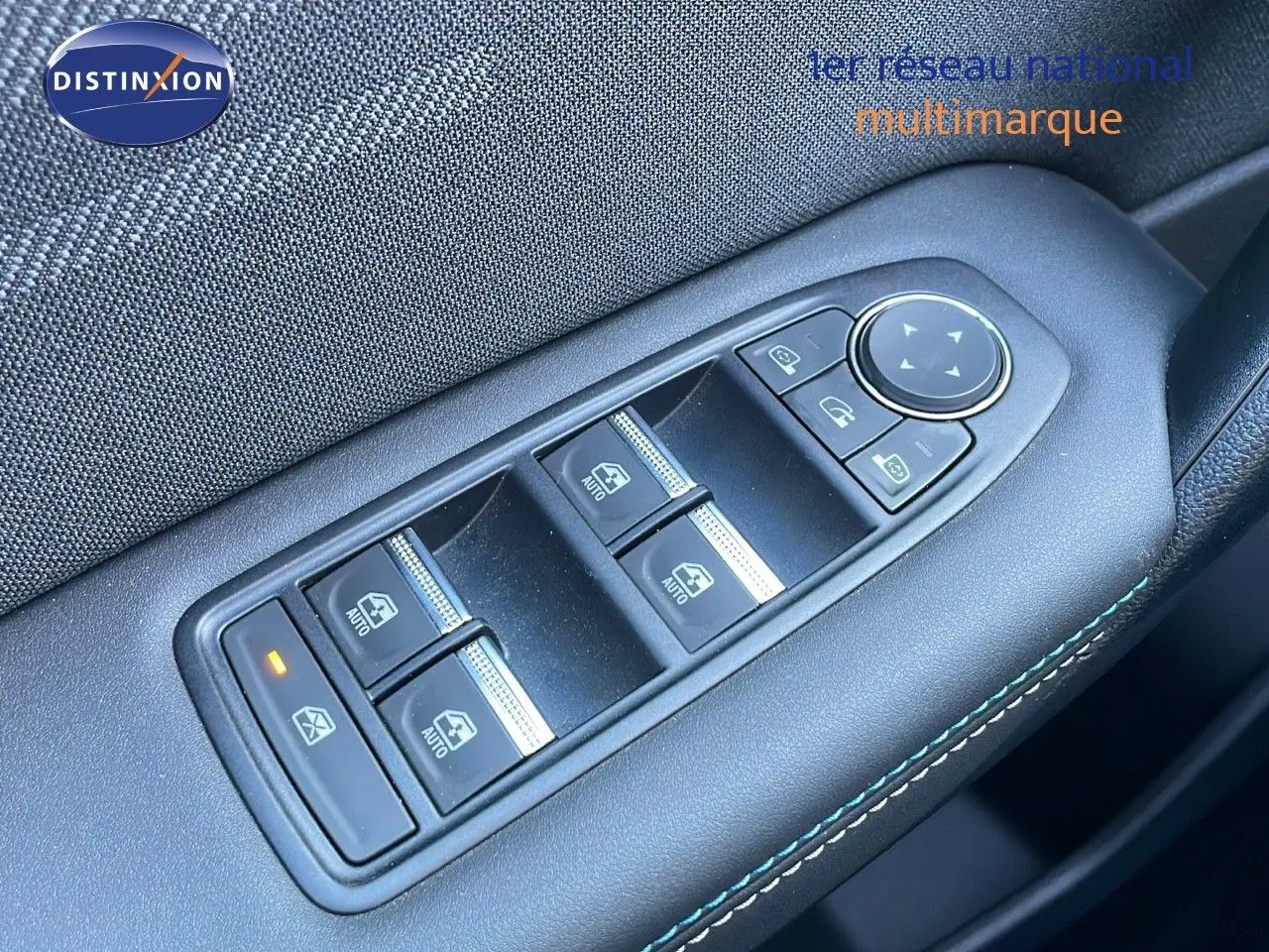 Panneau de commandes des vitres électriques et rétroviseurs sur la portière côté gauche d'un Renault Captur bleu iron metal toit noir.