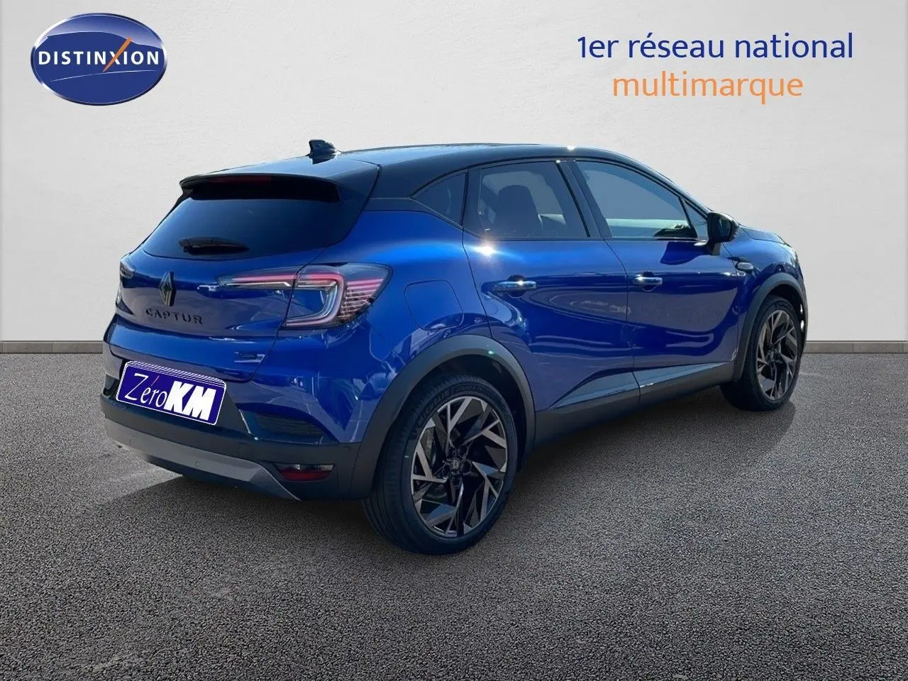 Renault Captur E-Tech hybride 2025 bleu Iron Metal avec toit noir, vue 3/4 arrière côté gauche, jantes noires distinctives.