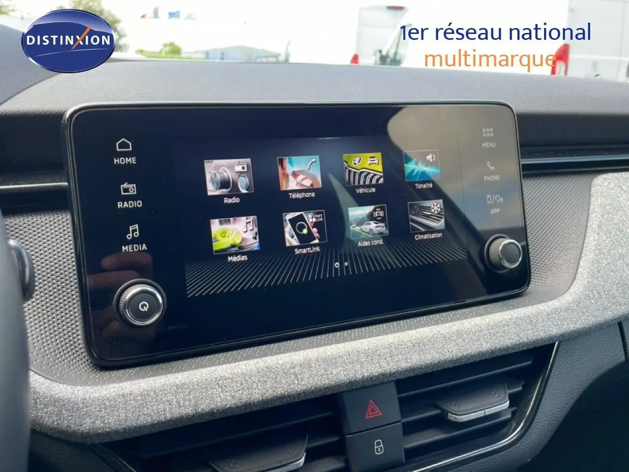Écran tactile central en gros plan dans l’habitacle gris noir du Skoda Scala blanc glacier 2025, version 1.0 TSI.
