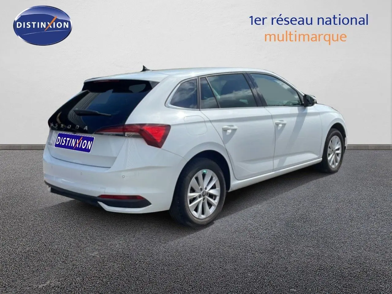 Vue 3/4 arrière droite d'une Skoda Scala blanche glacier avec vitres teintées et jantes alliage 16 pouces.
