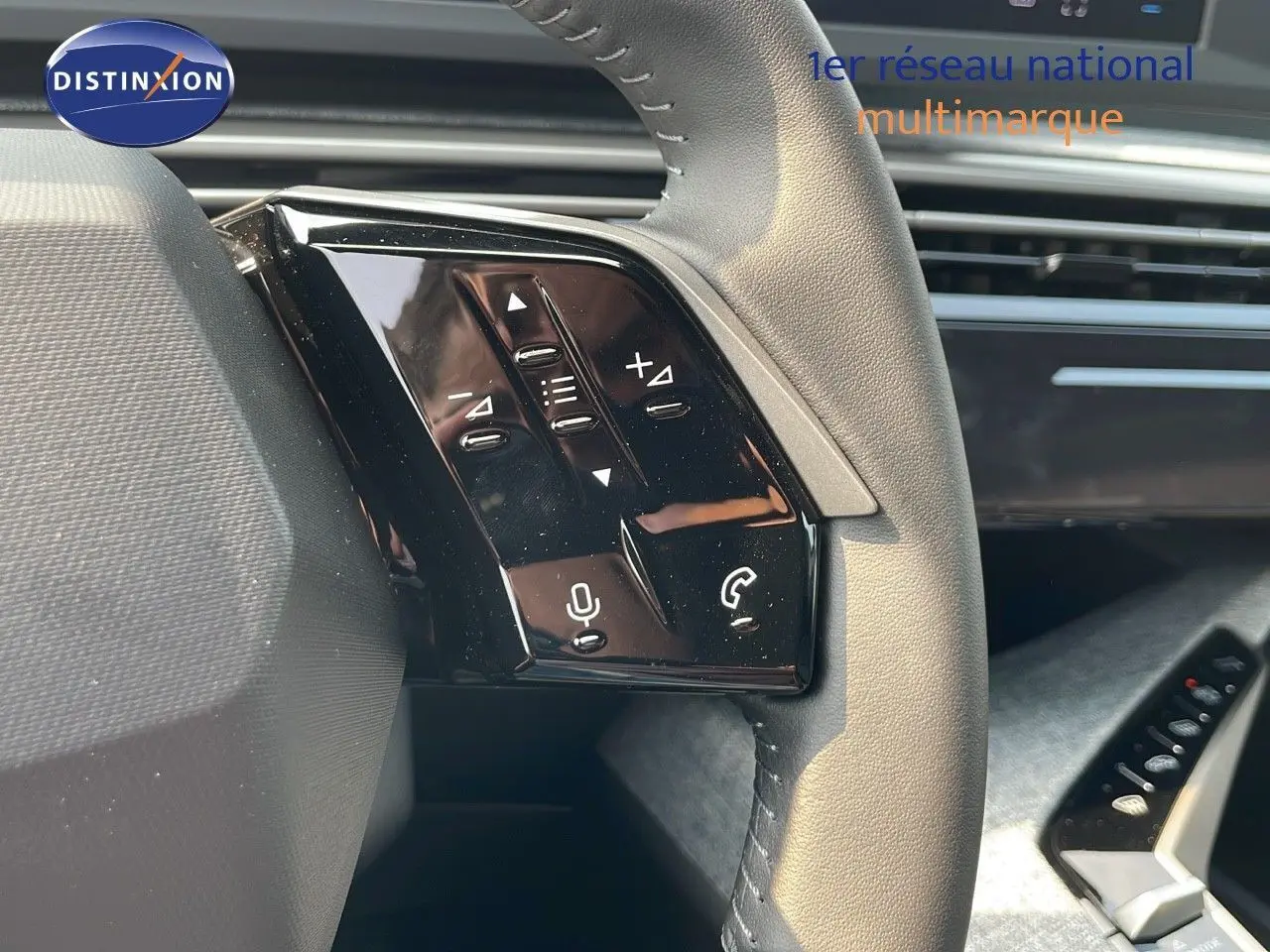 Gros plan sur les commandes au volant du Peugeot 3008 Hybrid gris Artense, mettant en valeur les boutons multifonctions.