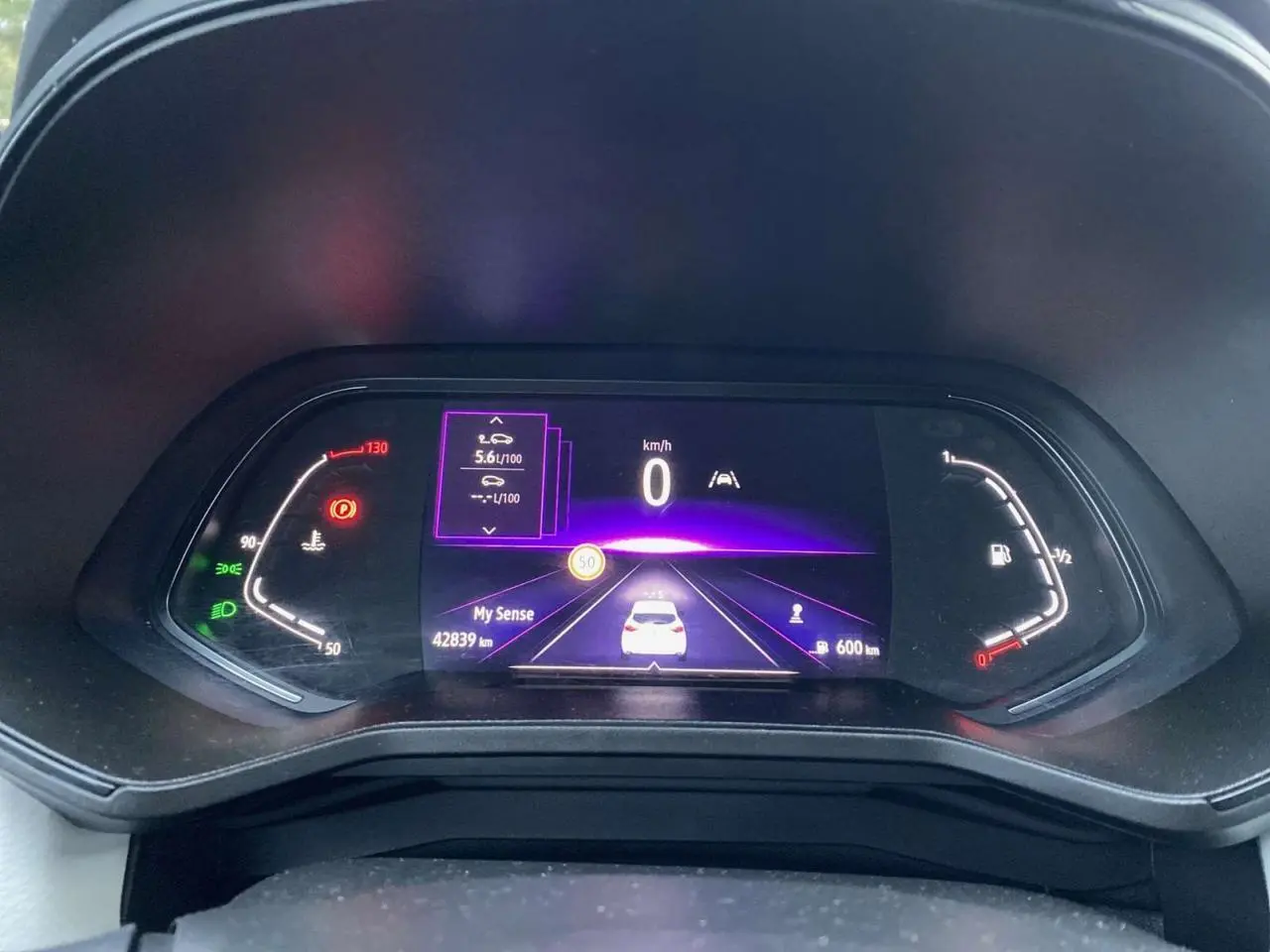 Tableau de bord numérique de Renault Clio blanche 2023 affichant vitesse, consommation et autonomie.