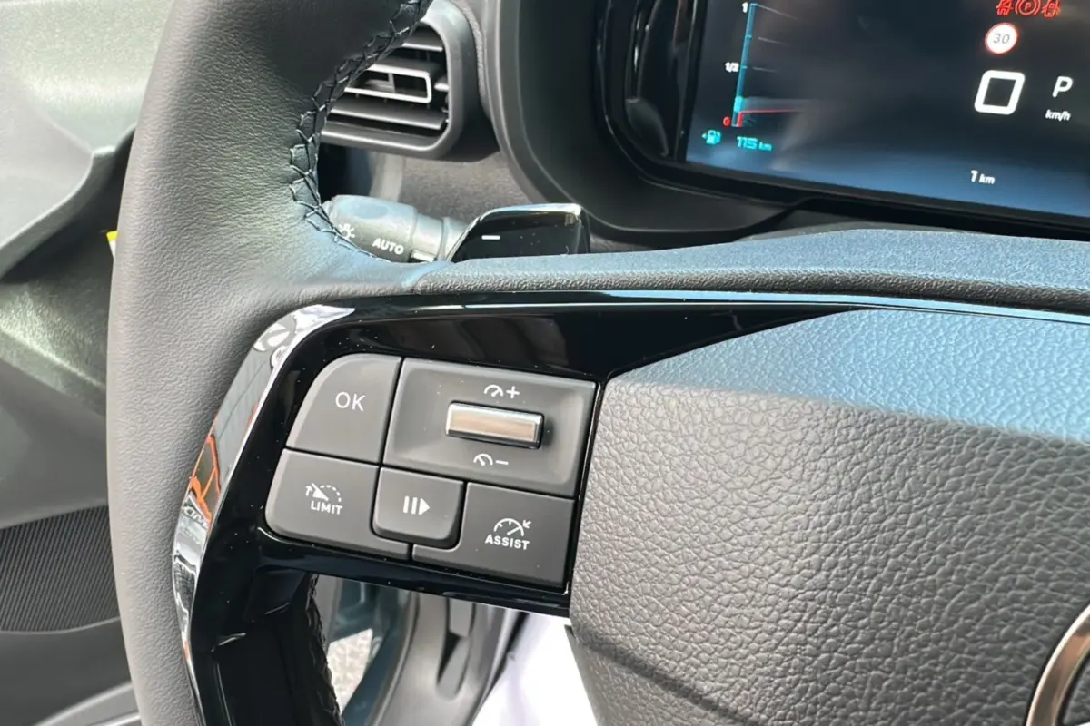 Gros plan sur les commandes au volant du Citroën Berlingo 2025 Kiama blue, avec tableau de bord numérique en arrière-plan.