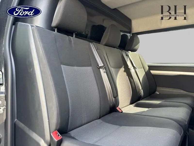 Banquette arrière noire vue de côté gauche dans un Peugeot Expert Fourgon 2022 avec vitres teintées.