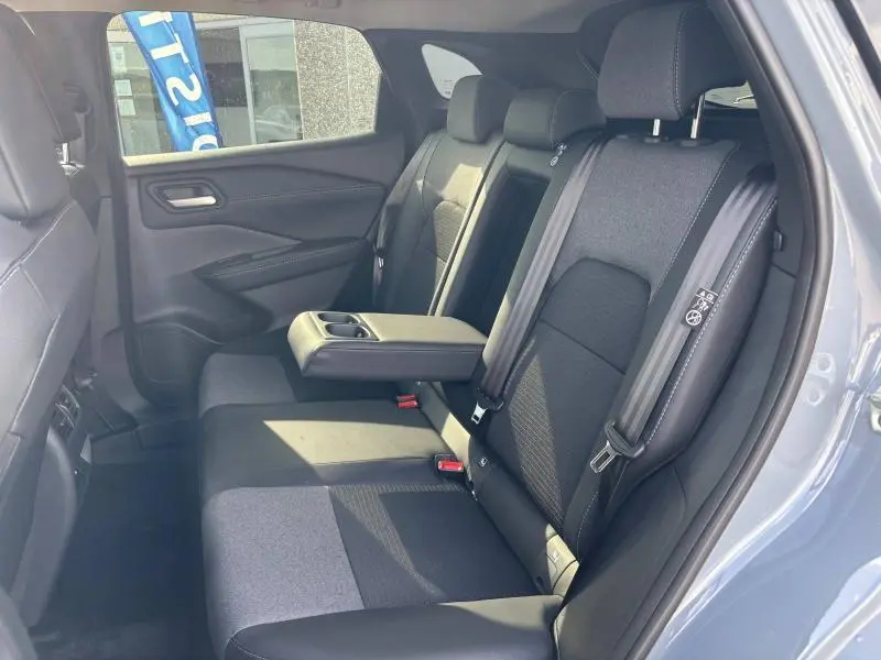 Vue intérieure sur la banquette arrière noire avec accoudoir central déployé du Nissan Qashqai e-POWER gris Argile 2024