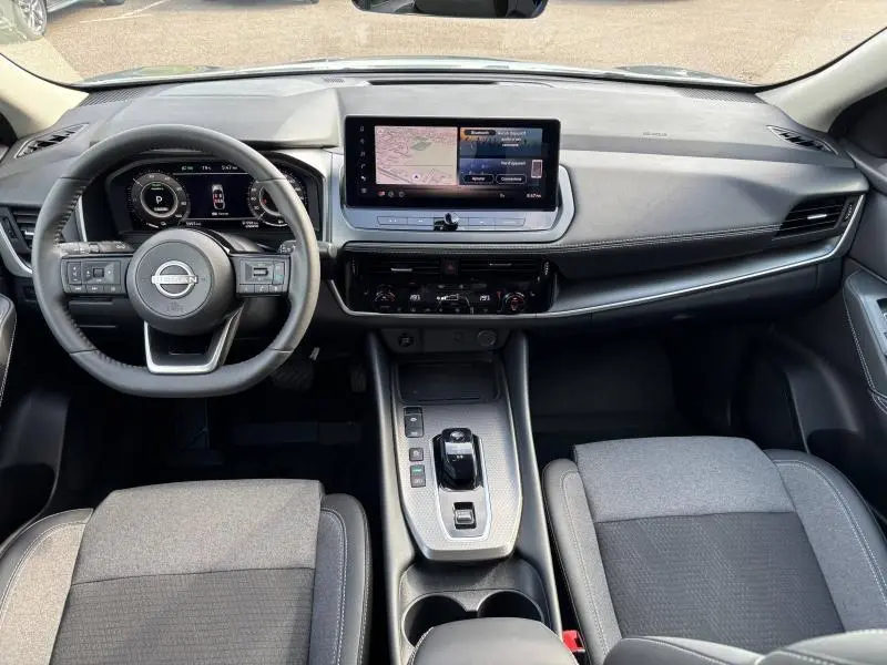 Intérieur du Nissan Qashqai e-POWER 2024, vue frontale du tableau de bord avec écran tactile et volant multifonction.