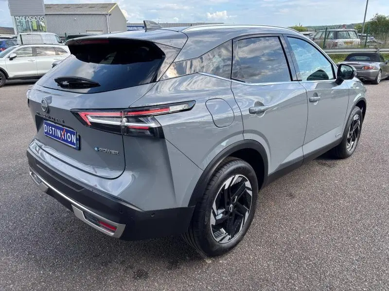 Vue 3/4 arrière droite du Nissan Qashqai e-POWER 2024 en gris Argile avec jantes alliage noires et vitres teintées.