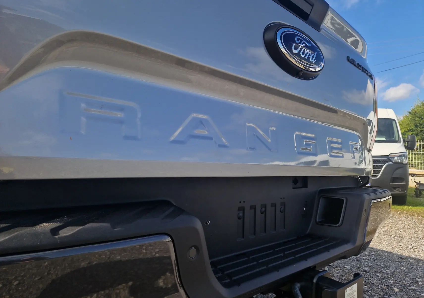 Gros plan sur l'arrière gris iconique du Ford Ranger Super Cabine 2025, mettant en valeur le logo et la benne robuste.