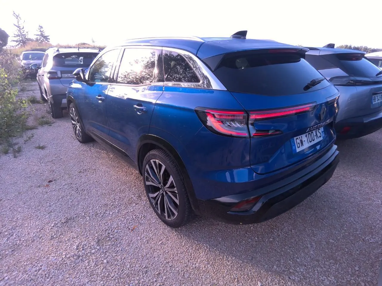 Vue 3/4 arrière droite d'un Renault Austral bleu métal foncé avec toit panoramique et jantes alliage 20 pouces.