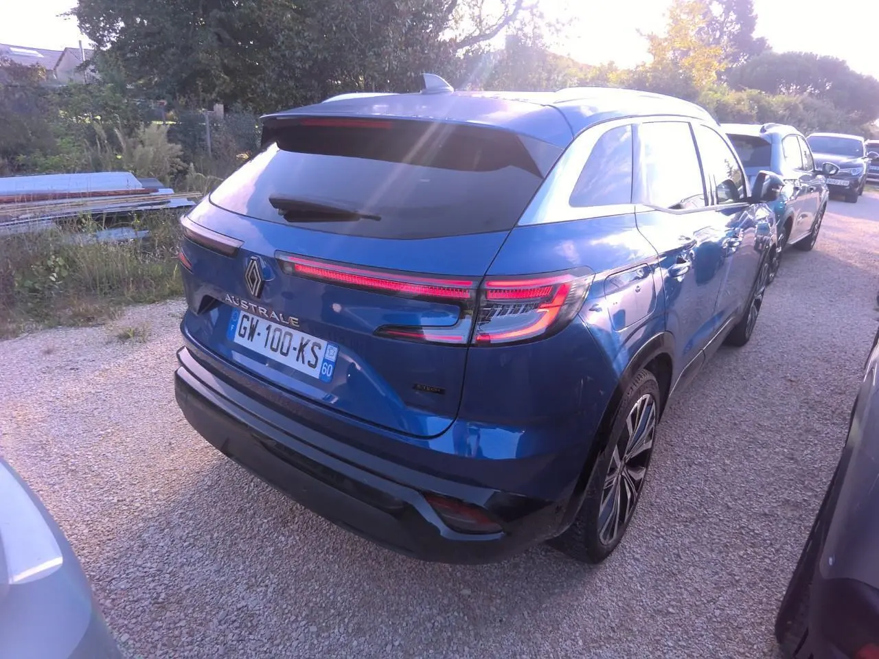 Vue 3/4 arrière droite d'un Renault Austral bleu métal foncé avec feux LED et toit panoramique.