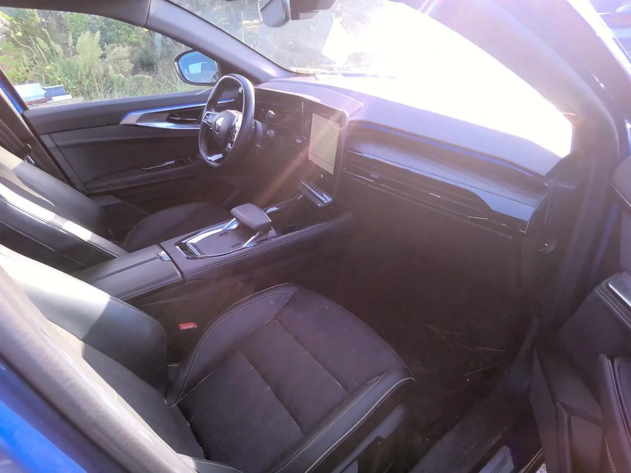 Intérieur côté conducteur du Renault Austral 2024 bleu métal, avec tableau de bord numérique et sellerie mixte noire.