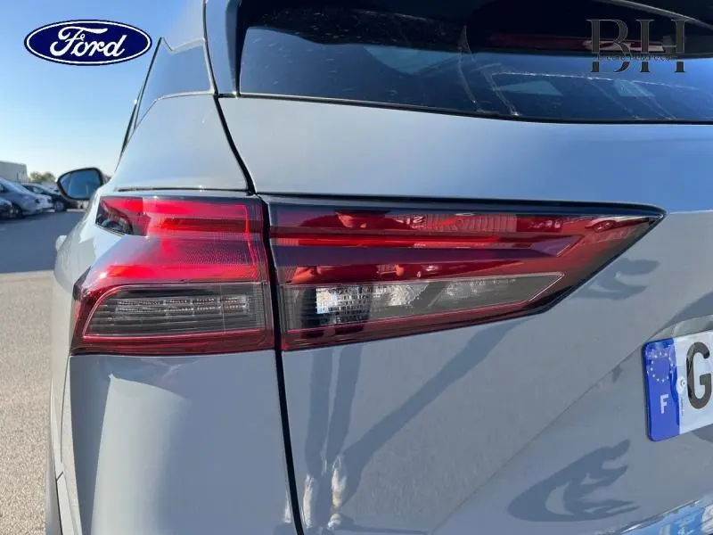 Gros plan sur le feu arrière droit d'un Nissan Qashqai 1.3 Mild Hybrid gris Argile, avec la carrosserie visible en arrière-plan.