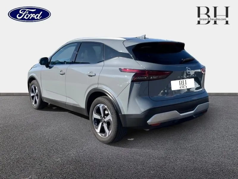 Vue 3/4 arrière droite d'un Nissan Qashqai 1.3 Mild Hybrid gris Argile avec feux arrière LED et jantes alu.