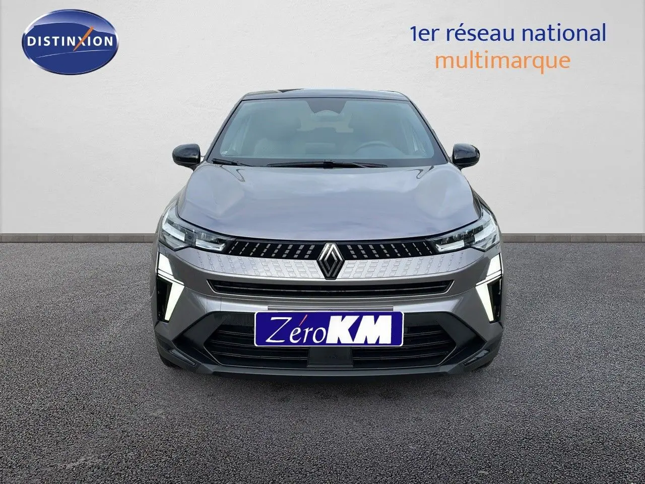 Vue de face du Renault Captur E-Tech hybride gris Cassiopée avec toit noir, feux LED allumés et calandre moderne.