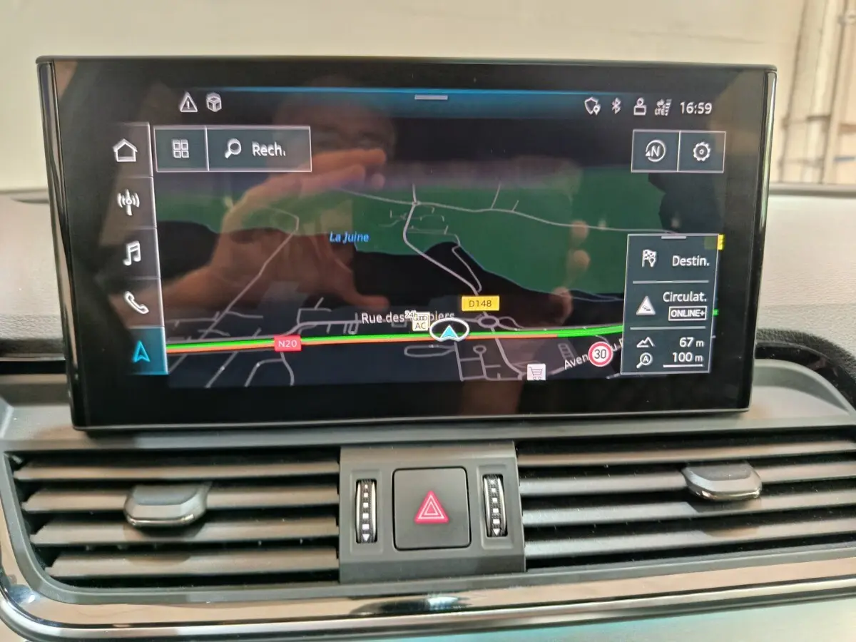 Vue rapprochée de l’écran tactile central de l’Audi Q5 2023 gris clair affichant la navigation GPS.