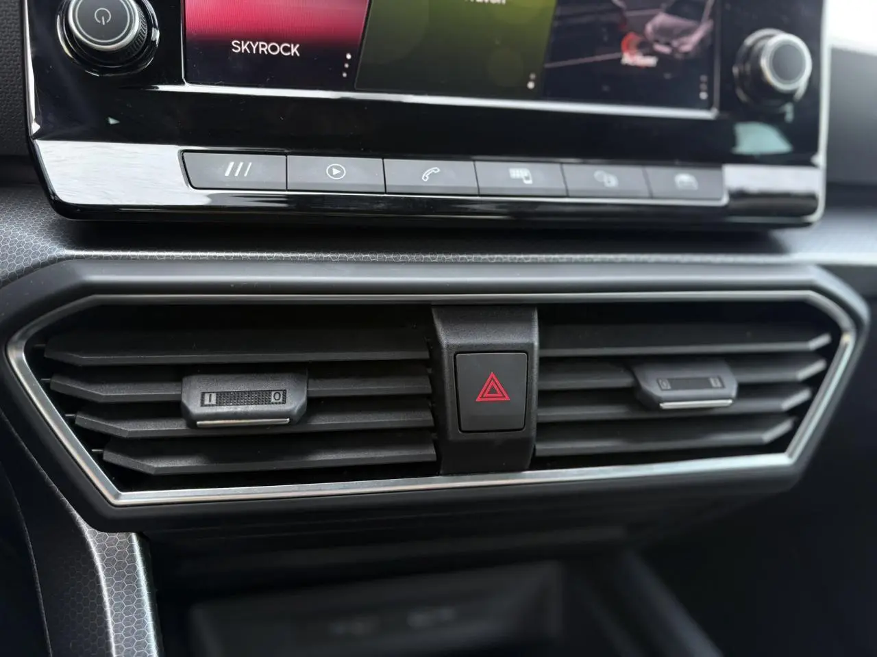 Détail des aérateurs centraux et bouton de warning sur le tableau de bord du SEAT LEON 2024 gris Magnétique.