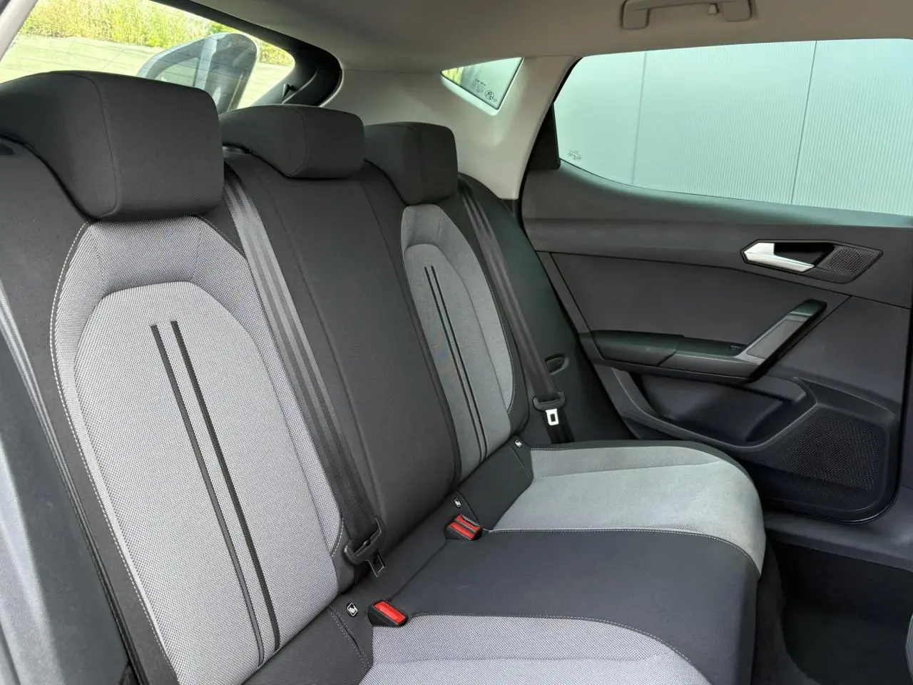 Vue latérale droite de la banquette arrière gris clair et foncé du SEAT LEON 2.0 TDI 150 DSG Style 2024 avec vitres surteintées.