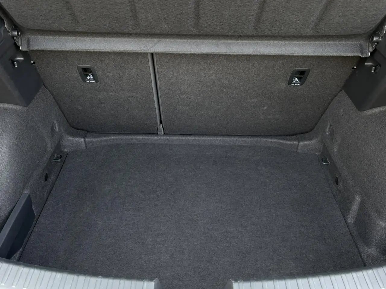Coffre vide de la SEAT LEON 2024 gris magnétique, vue intérieure arrière montrant la moquette et les fixations Isofix.