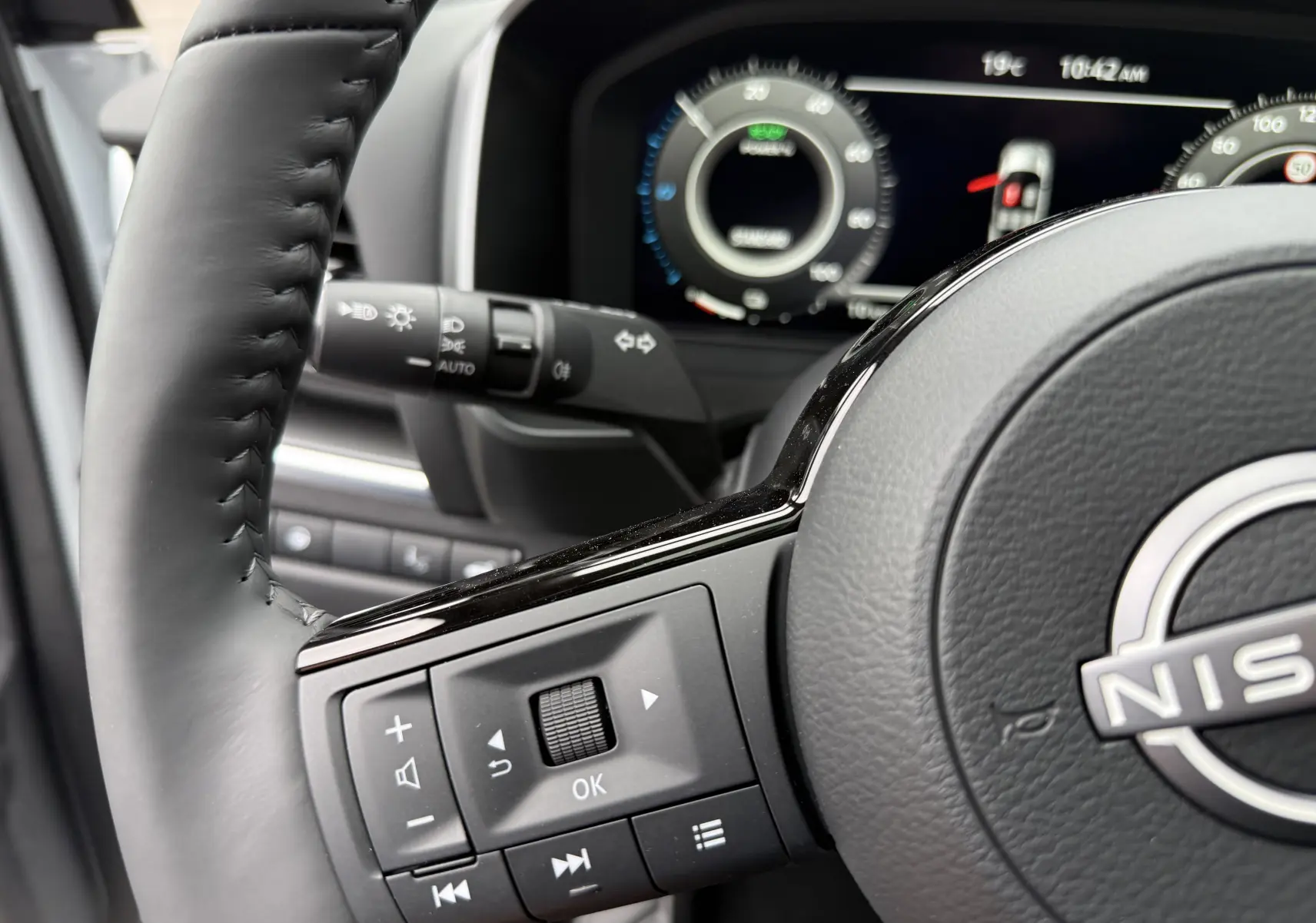 Gros plan sur le volant cuir noir du Nissan Qashqai 2025 avec commandes multifonctions et tableau de bord numérique.