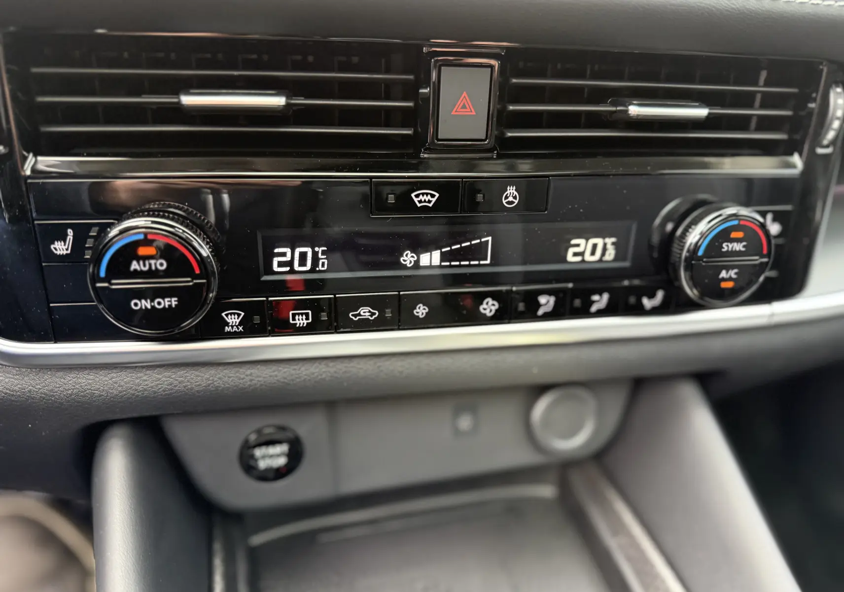 Panneau de climatisation numérique du Nissan Qashqai 2025 avec réglage à 20°C et commandes tactiles sur console noire.