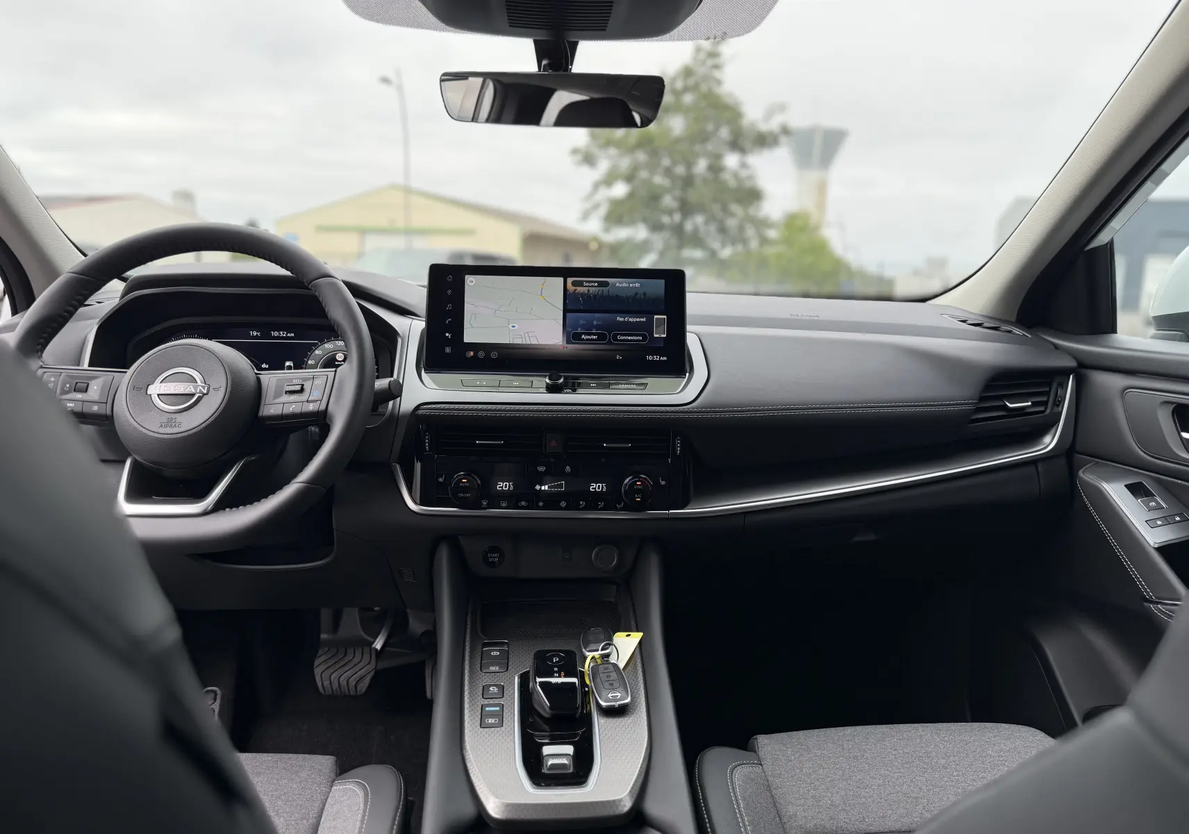 Vue intérieure frontale du Nissan Qashqai 2025, tableau de bord moderne avec écran tactile et volant multifonction noir.