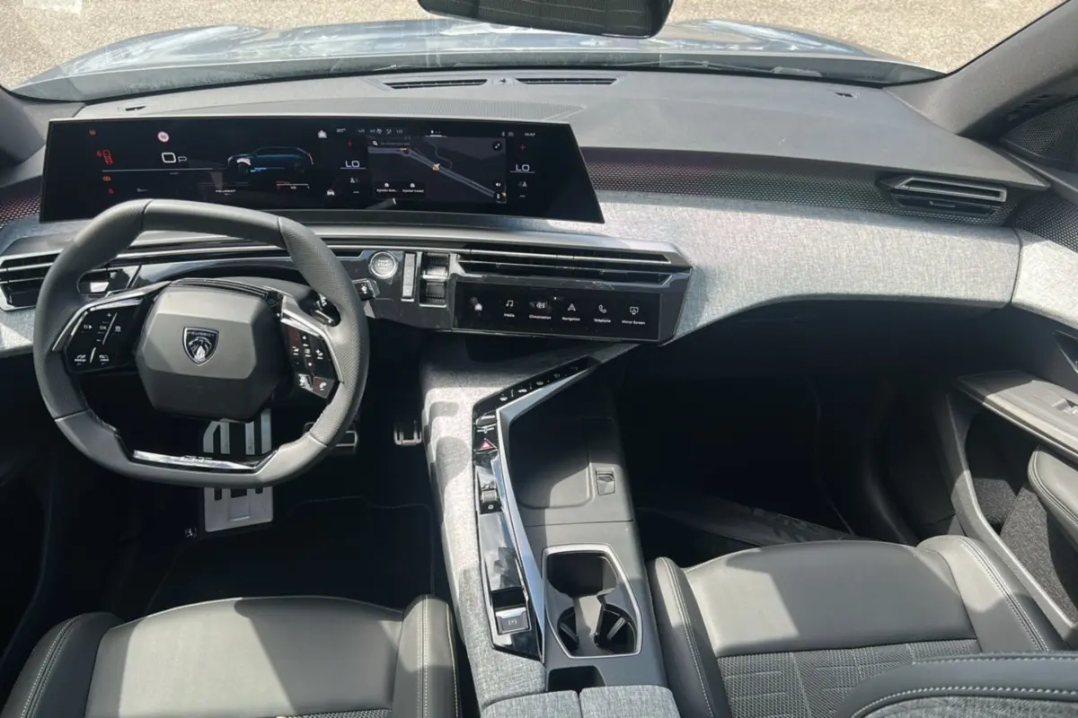 Vue intérieure du poste de conduite du Peugeot 5008 Hybrid 145 GT 7 places 2025, avec tableau de bord numérique et sellerie cuir noire.