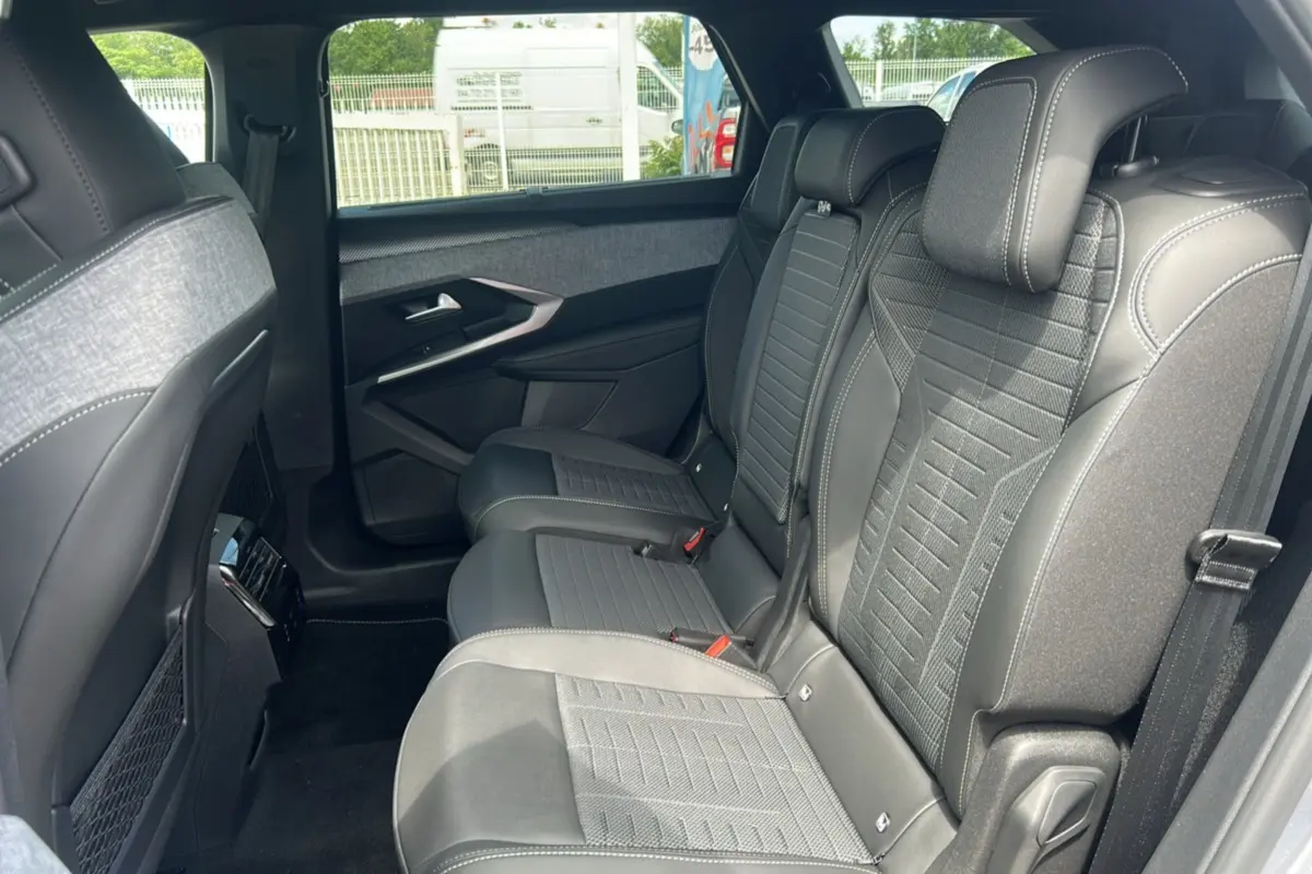 Vue latérale droite de l'habitacle arrière du Peugeot 5008 Hybrid 145 GT 7 places avec sièges en cuir gris et tissu.