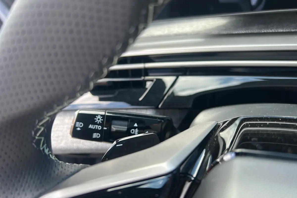 Gros plan sur la commande des feux et clignotants côté gauche du volant du Peugeot 5008 Hybrid 145 GT 7 places gris Artense 2025.