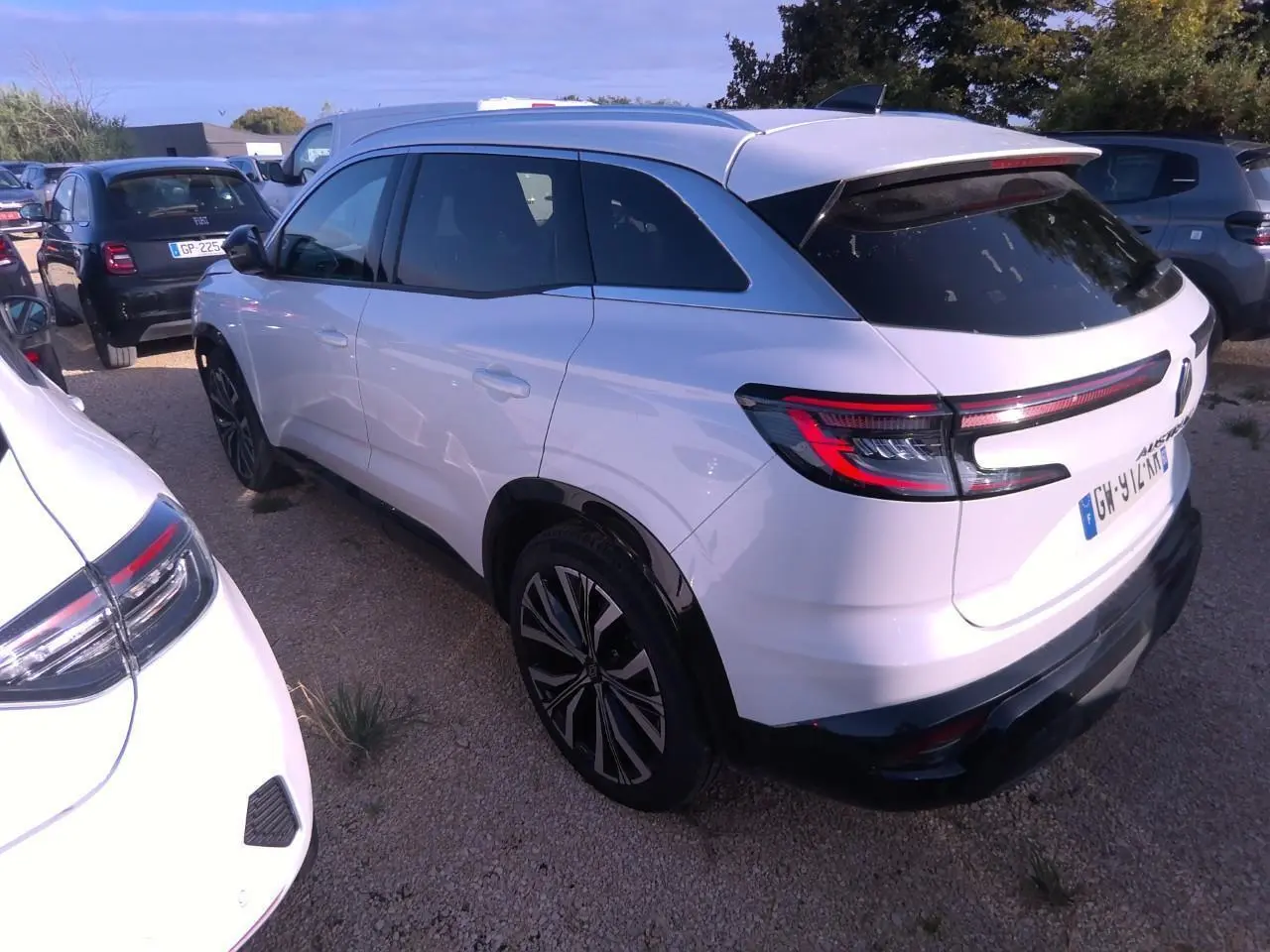 Vue 3/4 arrière droite du Renault Austral blanc nacré avec jantes alliage noires et vitres teintées.