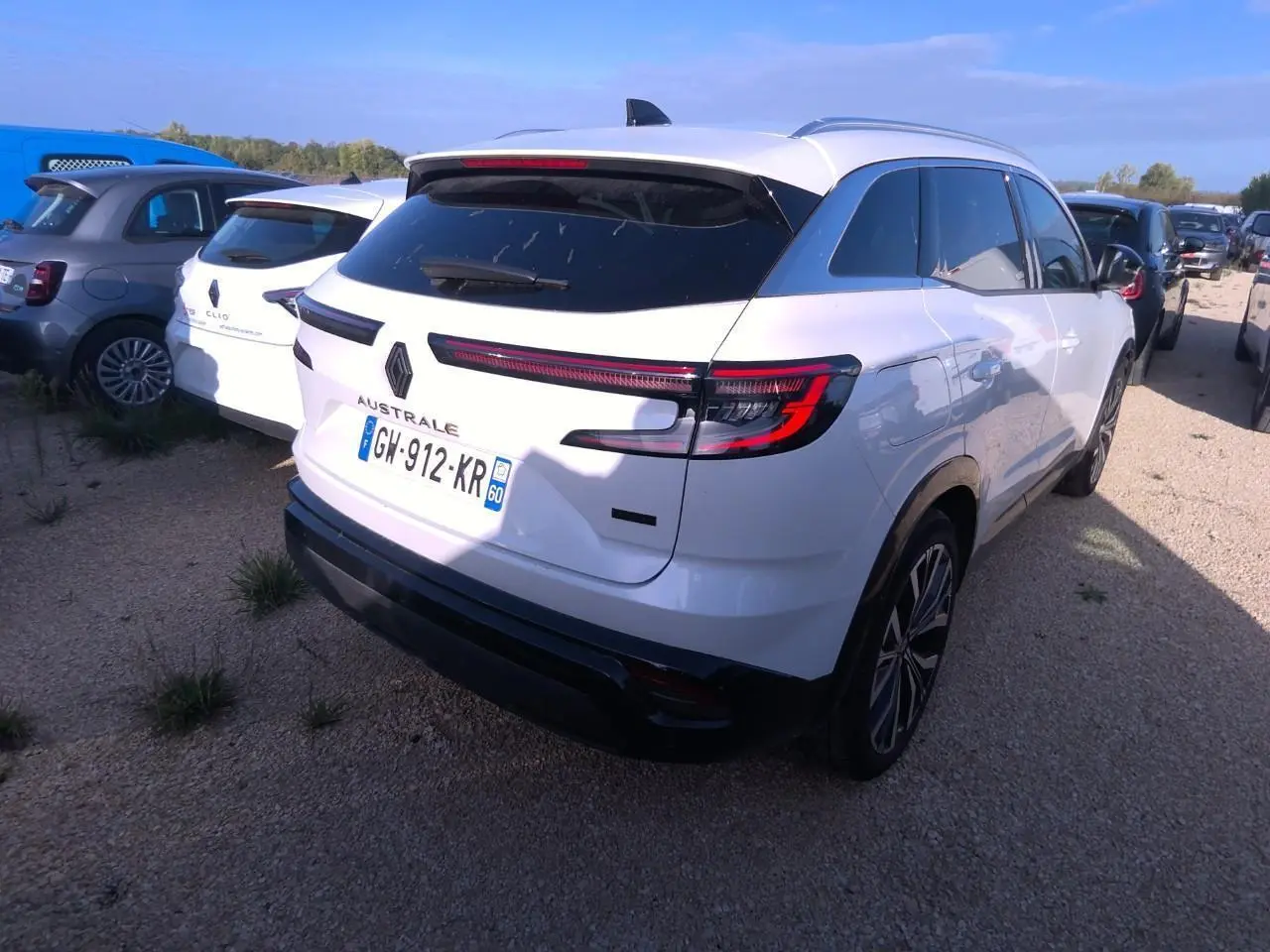 Vue 3/4 arrière droite d'un Renault Austral blanc nacré avec feux arrière LED et toit noir panoramique.
