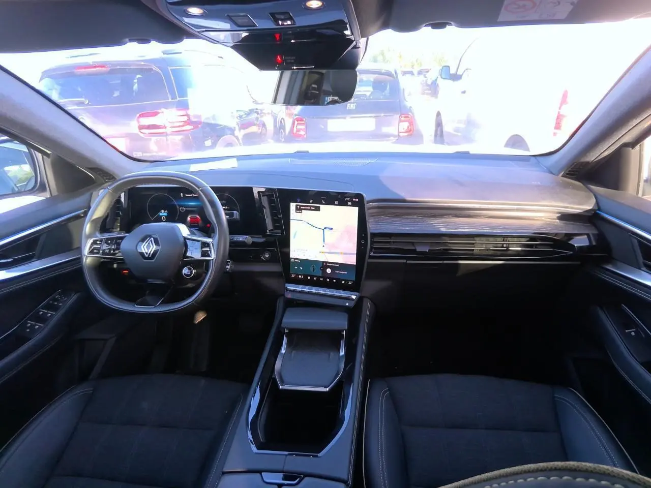 Intérieur noir du Renault Austral 2024, vue de face sur le tableau de bord avec écran tactile central et volant multifonction.