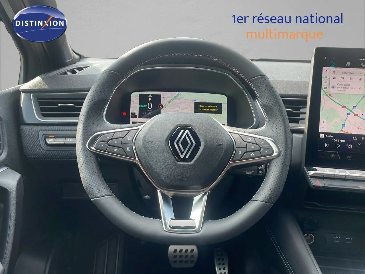 Vue centrée sur le volant cuir perforé du Renault Captur E-Tech hybride 2025 avec tableau de bord numérique et écran tactile.