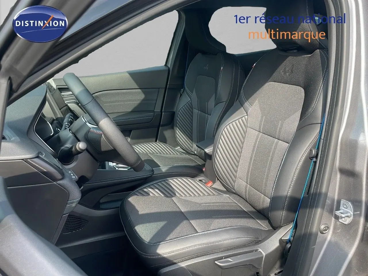 Intérieur avant du Renault Captur E-Tech hybride 2025, sièges noirs avec surpiqûres et logo Alpine visibles.