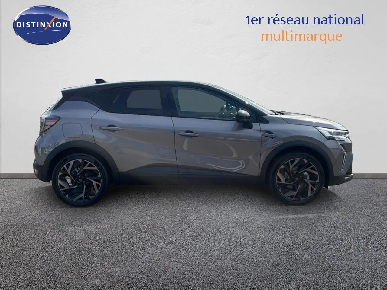 Profil droit du Renault Captur E-Tech hybride 2025 gris cassiopée métal avec toit noir et jantes noires stylées.