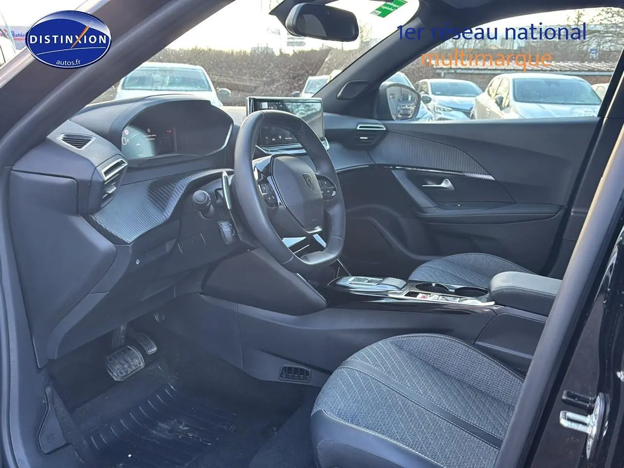 Vue intérieure côté conducteur du Peugeot 2008 noir 2025, mettant en valeur le tableau de bord et la console centrale moderne.