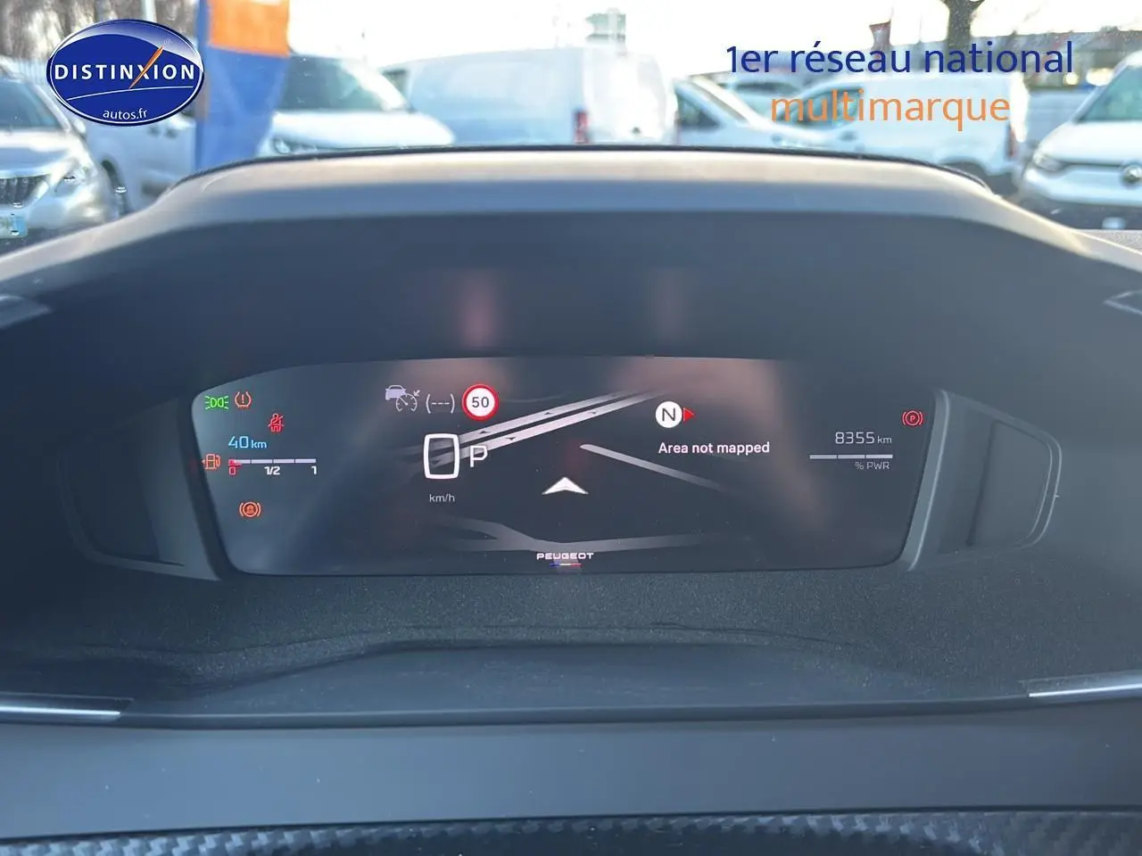 Vue rapprochée du tableau de bord numérique du Peugeot 2008 noir, affichant la vitesse et les alertes de conduite.